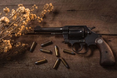 Gun and bullets on wooden table