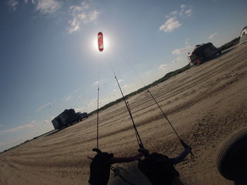 Fish-eye lens shot cropped person kiteboarding at beach against sky