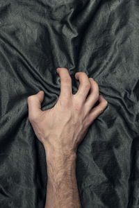 Directly above shot of man hand on bed