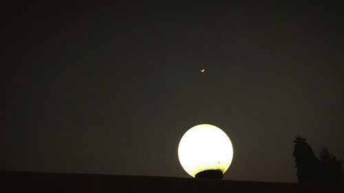 Low angle view of illuminated moon against sky at night