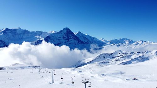 Scenic view of snowcapped mountains against clear blue sky