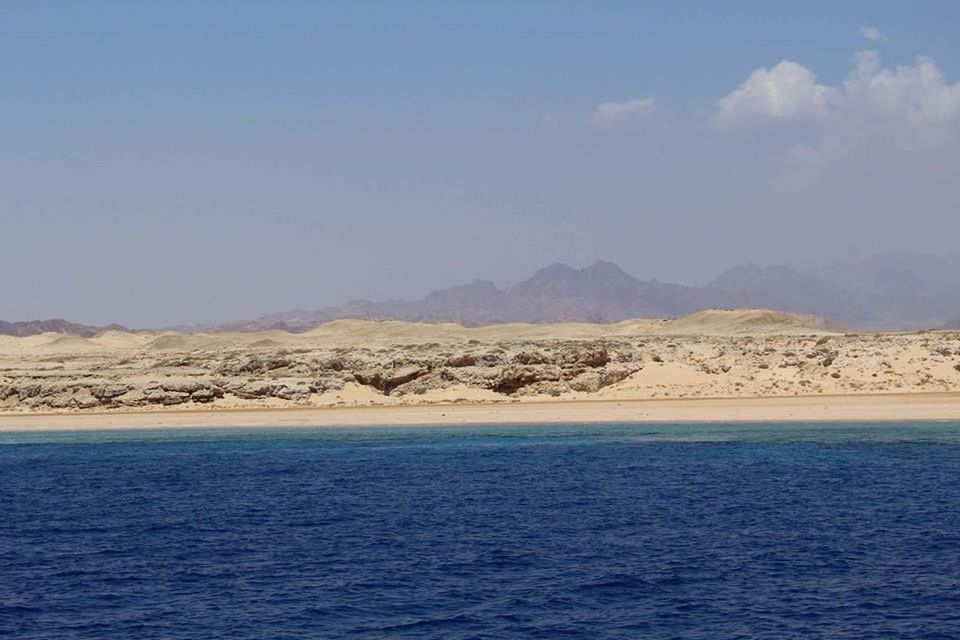 SCENIC VIEW OF SEA AND MOUNTAINS AGAINST CLEAR SKY