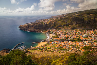 High angle view of sea and mountains against sky