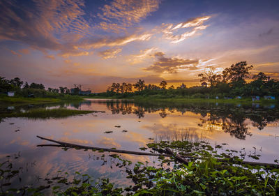 Scenic view of lake against sky at sunset