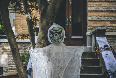 Halloween decoration of a skeleton and spiders at the stoop of a building