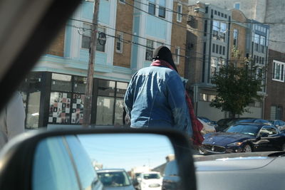 Rear view of man driving car on street