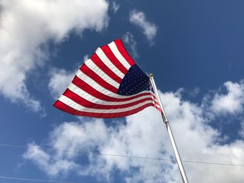 Low angle view of american flag against sky