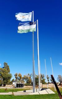 Low angle view of flag against blue sky