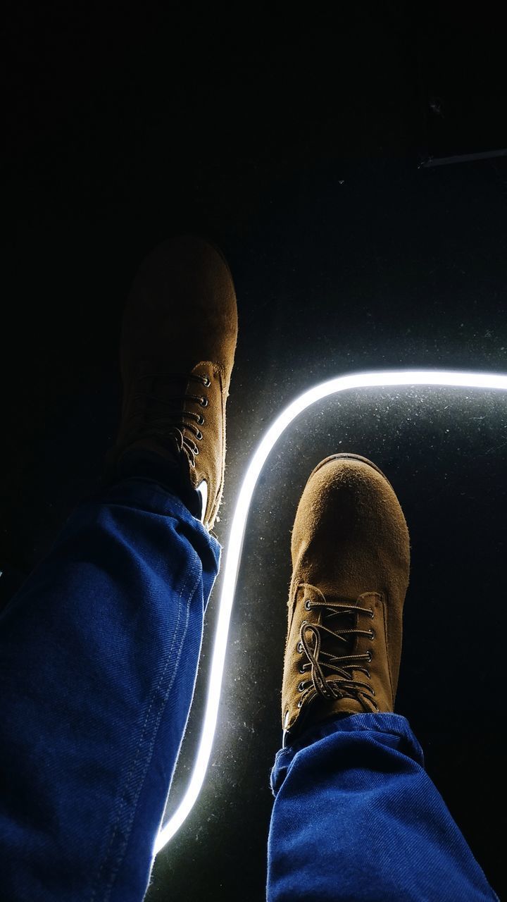 LOW SECTION OF PEOPLE SITTING ON ILLUMINATED STAGE