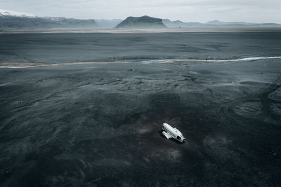 Cinematic aerial view of dc-3 airplane wreckage at black beach, sólheimasandur, iceland.