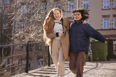 Female friends walking together ourdoors on walkway in city