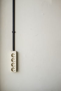 Close-up of electric lamp on wall at home