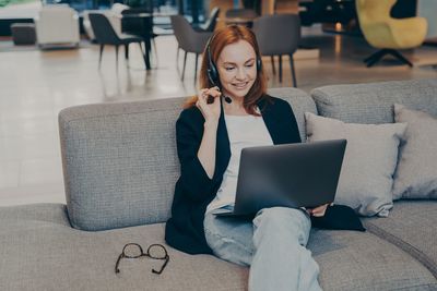 Young woman using laptop while sitting at home