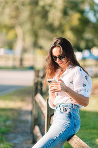 Young woman looking away while standing outdoors