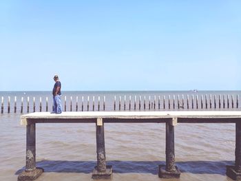Man looking at sea against clear sky