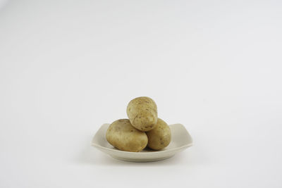 Close-up of cookies in plate against white background