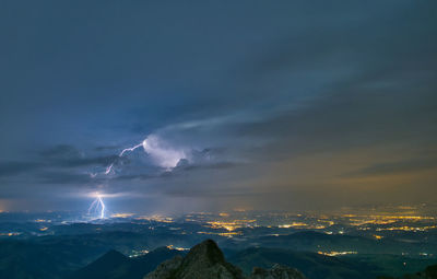 Scenic view of mountains against night sky during thunderstorm 