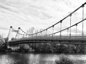 Bridge over river against cloudy sky