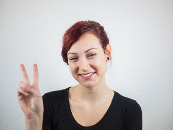 Portrait of smiling young woman against white background