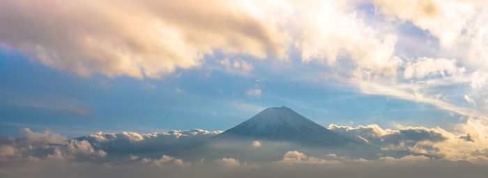 Panoramic view of volcanic mountain against cloudy sky