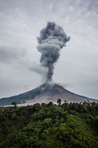 Smoke emitting from volcanic mountain against sky