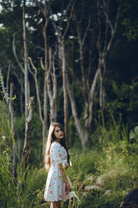 Side view portrait of young woman standing in forest