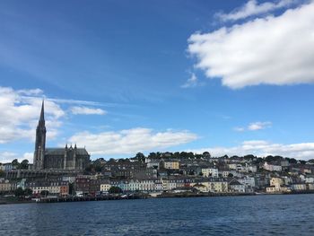 Buildings at waterfront against cloudy sky - cobh, ireland