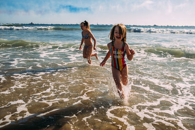 Girls running onto the beach after air show in california