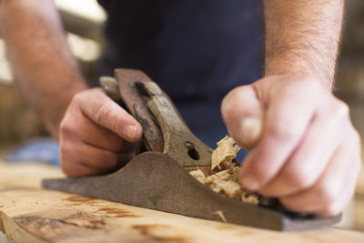 Midsection of carpenter working in workshop