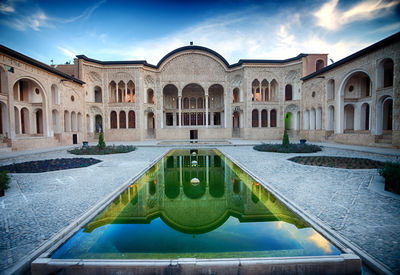 Fountain in swimming pool against sky