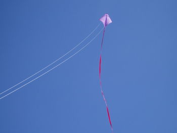 Low angle view of vapor trail against clear blue sky