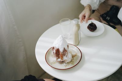 High angle view of hand holding ice cream in plate