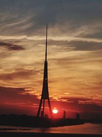 Silhouette of tower against sky during sunset