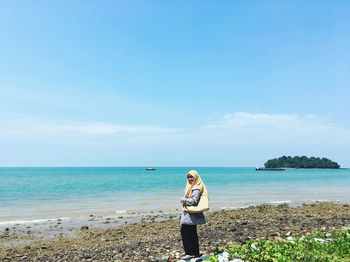 Side view of woman standing on shore at beach