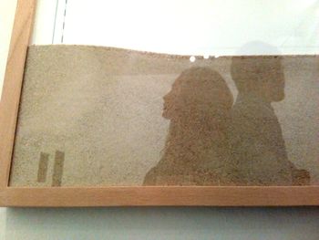 Rear view of woman sitting against wall at home