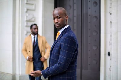 Side view portrait of well-dressed businessman standing in city