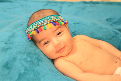 Close-up portrait of cute baby lying in swimming pool