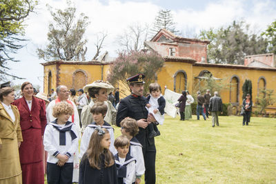 Group of people standing outside house