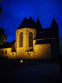 Low angle view of illuminated building against sky at dusk