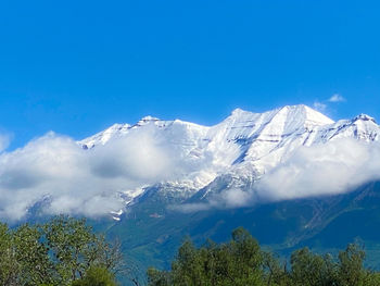 Scenic view of snowcapped mountains against blue sky