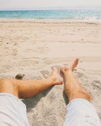Low section of man resting on beach