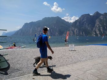 Rear view of man on beach against sky