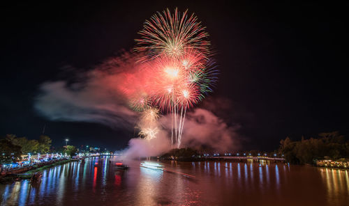 Firework display over river at night