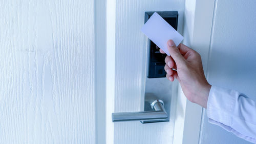 Midsection of man holding white door