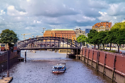 Bridge over river in city against sky