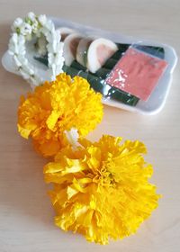 Close-up high angle view of yellow flowers on table