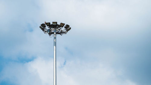 Low angle view of floodlight against cloudy sky