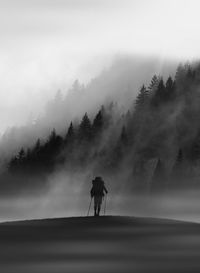 Man and dog on mountain against sky