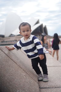 Low angle view of a kid standing against wall