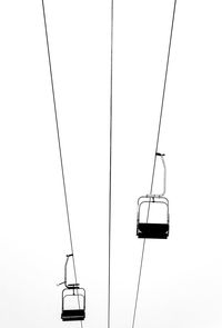 Low angle view of overhead cable car against sky